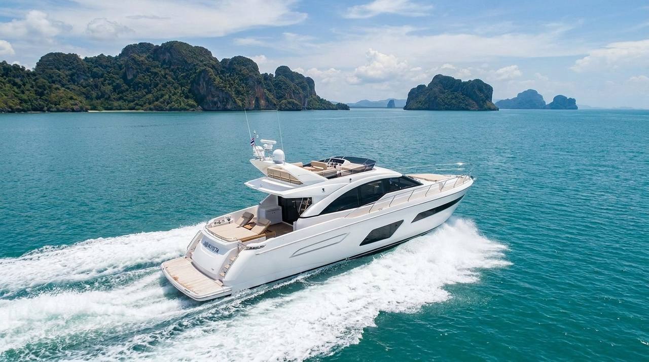 Motor yacht cruising past limestone islands on a long-distance route from Phuket